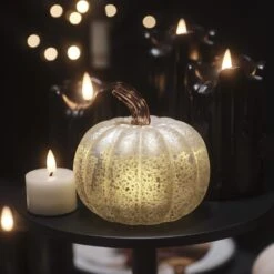 Citrouille Lumineuse En Verre à La Patine Blanche 25 Citrouille Lumineuse En Verre à La Patine Blanche -Noel Deco Magasin citrouille lumineuse en verre a la patine blanche sur une table basse