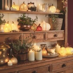 Lot De 8 Citrouilles Lumineuses En Verre à La Patine Blanche 13 Lot De 8 Citrouilles Lumineuses En Verre à La Patine Blanche -Noel Deco Magasin une selection de citrouilles lumineuses de differentes tailles sur une etagere